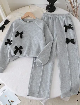 Set de 2 piezas de top de manga larga de cuello redondo gris y pantalones de pierna ancha con decoración de lazo para niñas jóvenes, otoño/inviern - Shein - FashionsVida
