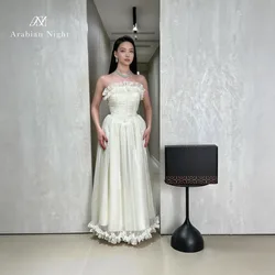 Ivory strapless sleeveless floor-length formal gown featuring a draped neckline and a lace-trimmed hem