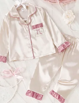 Conjunto de 2 piezas para niñas con top largo de manga con volantes de satén de unicolor y pantalones con bolsillos y bordado, ropa de estar en casa - Shein - FashionsVida